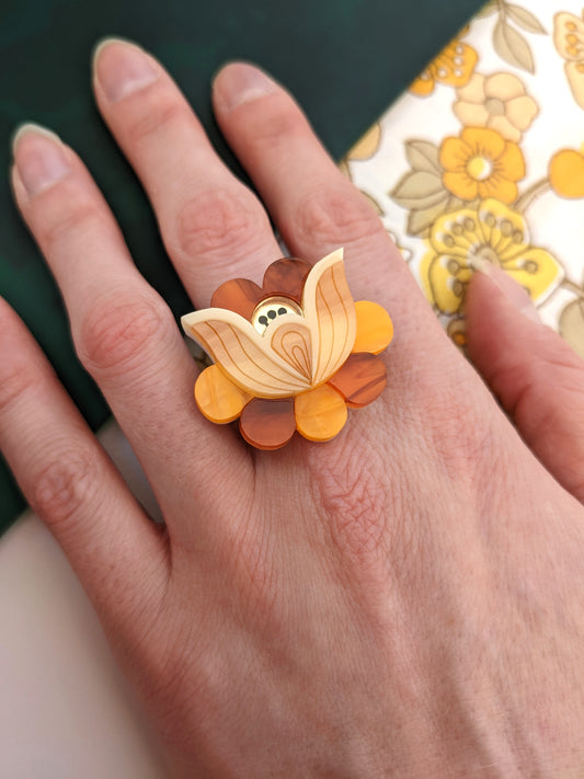 A hand wearing the acrylic Folk Floral Ring with a patterned band, showcasing the ring's folk floral design with multiple colors. Acrylic jewelry jewellery 
