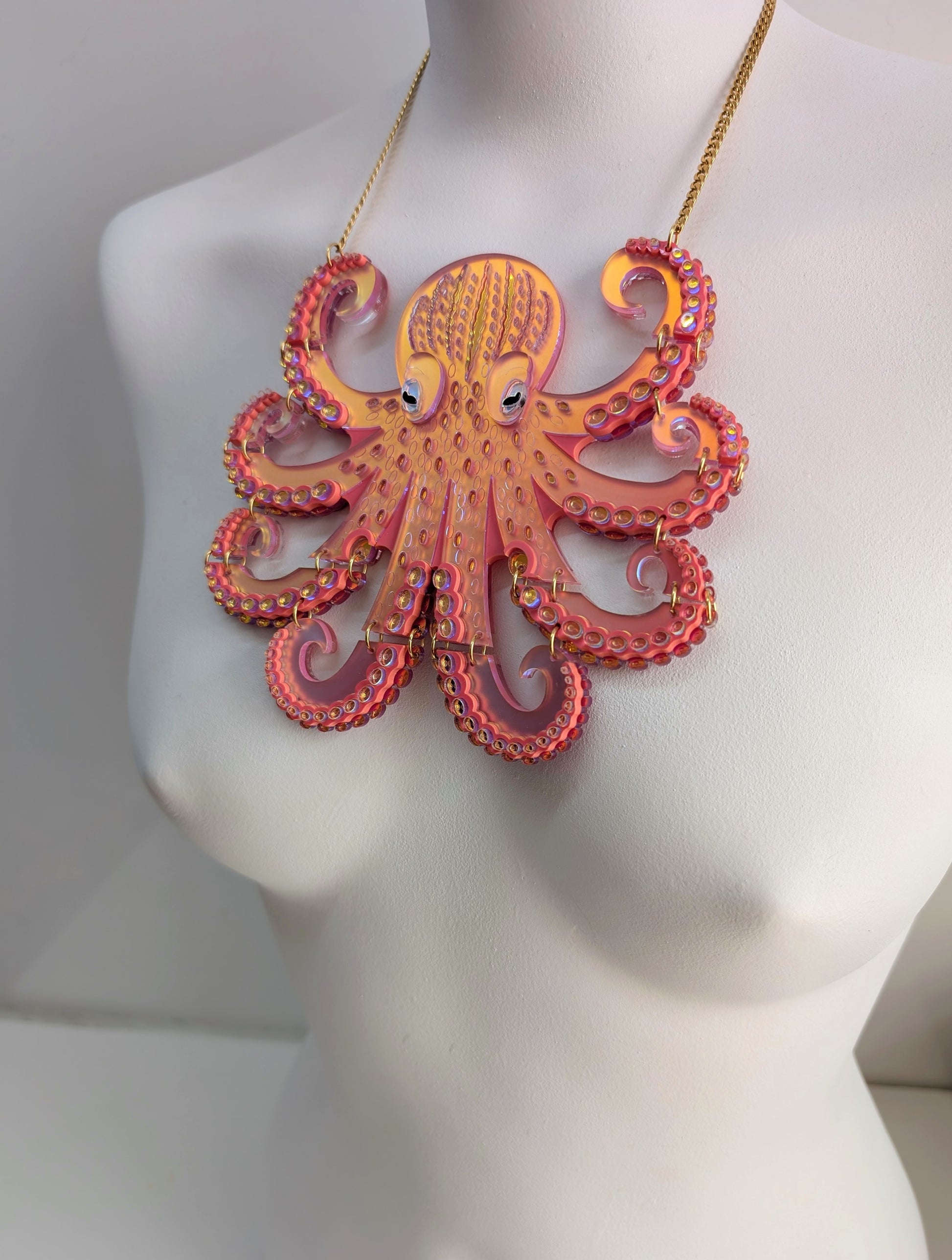 Laser cut acrylic iridescent coral octopus necklace on a mannequin with a plain background