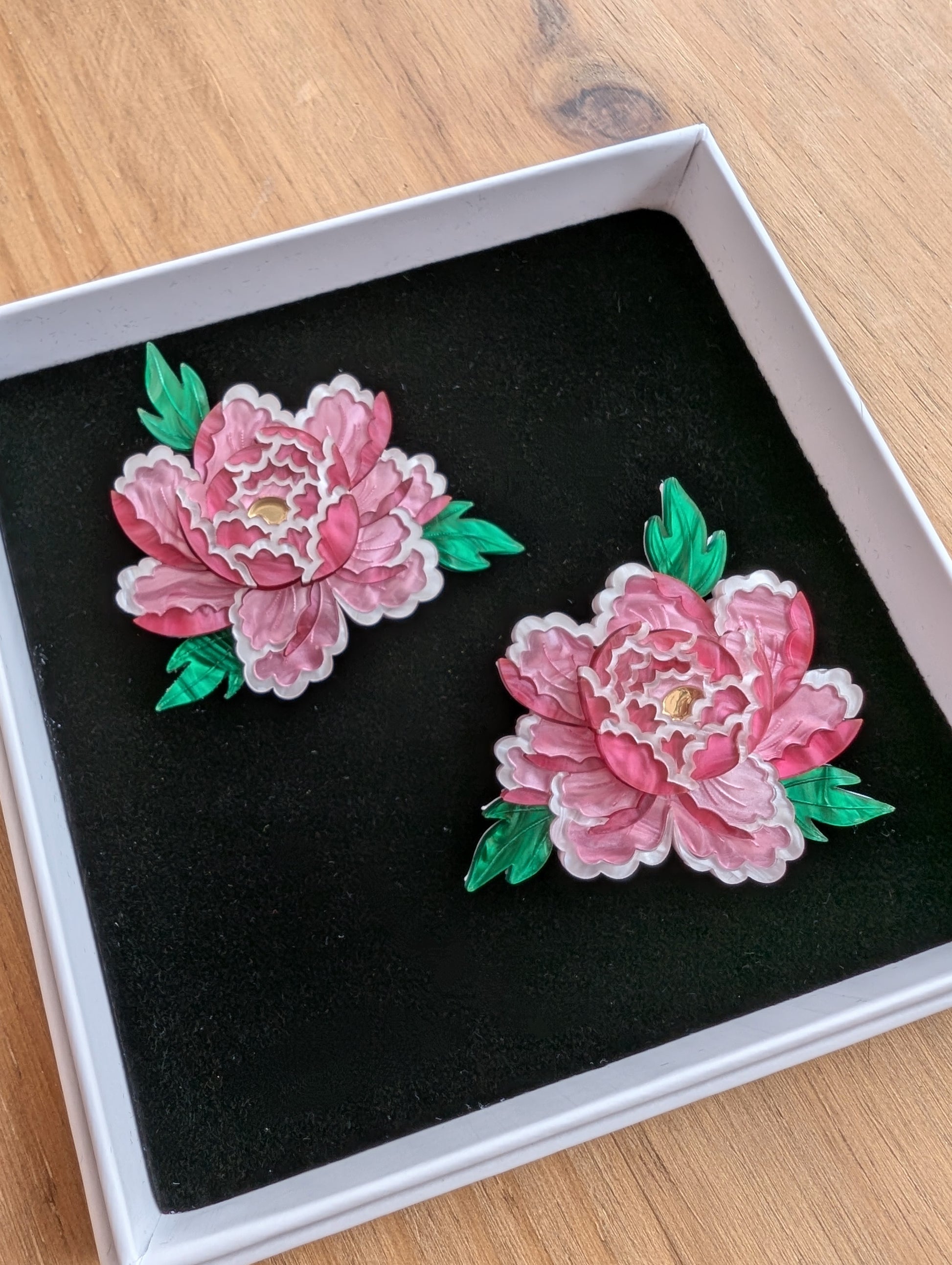 Handmade laser cut acrylic jewellery, specifically mini brooches in the shape of peony inspired flowers
