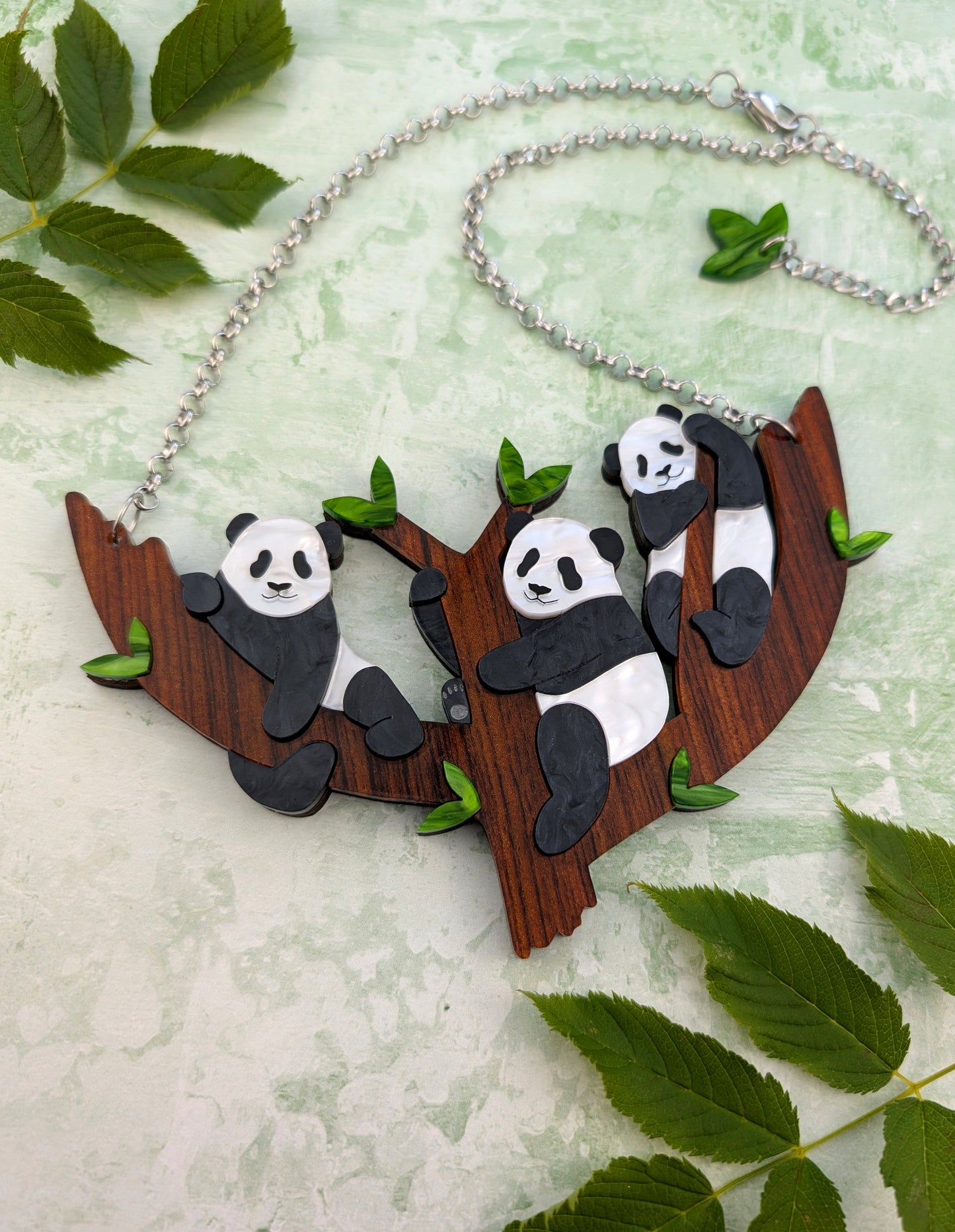  panda necklace design on a branch surrounded by leaves