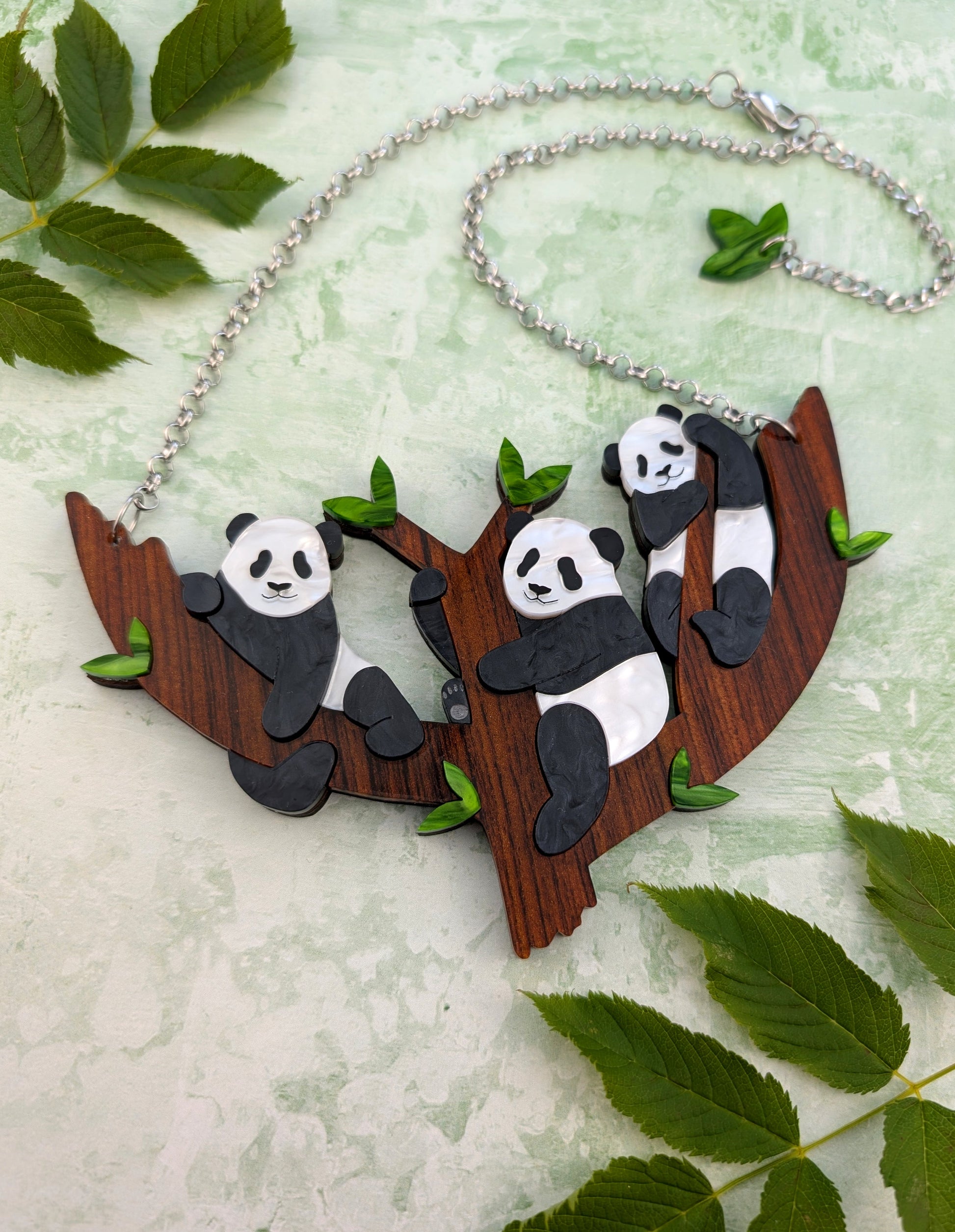  panda necklace design on a branch surrounded by leaves
