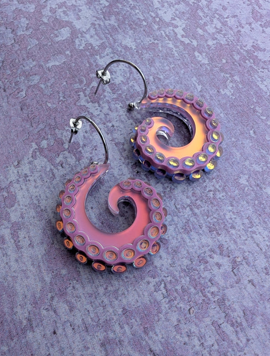 Pair of octopus tentacle inspired earrings on a textured purple background