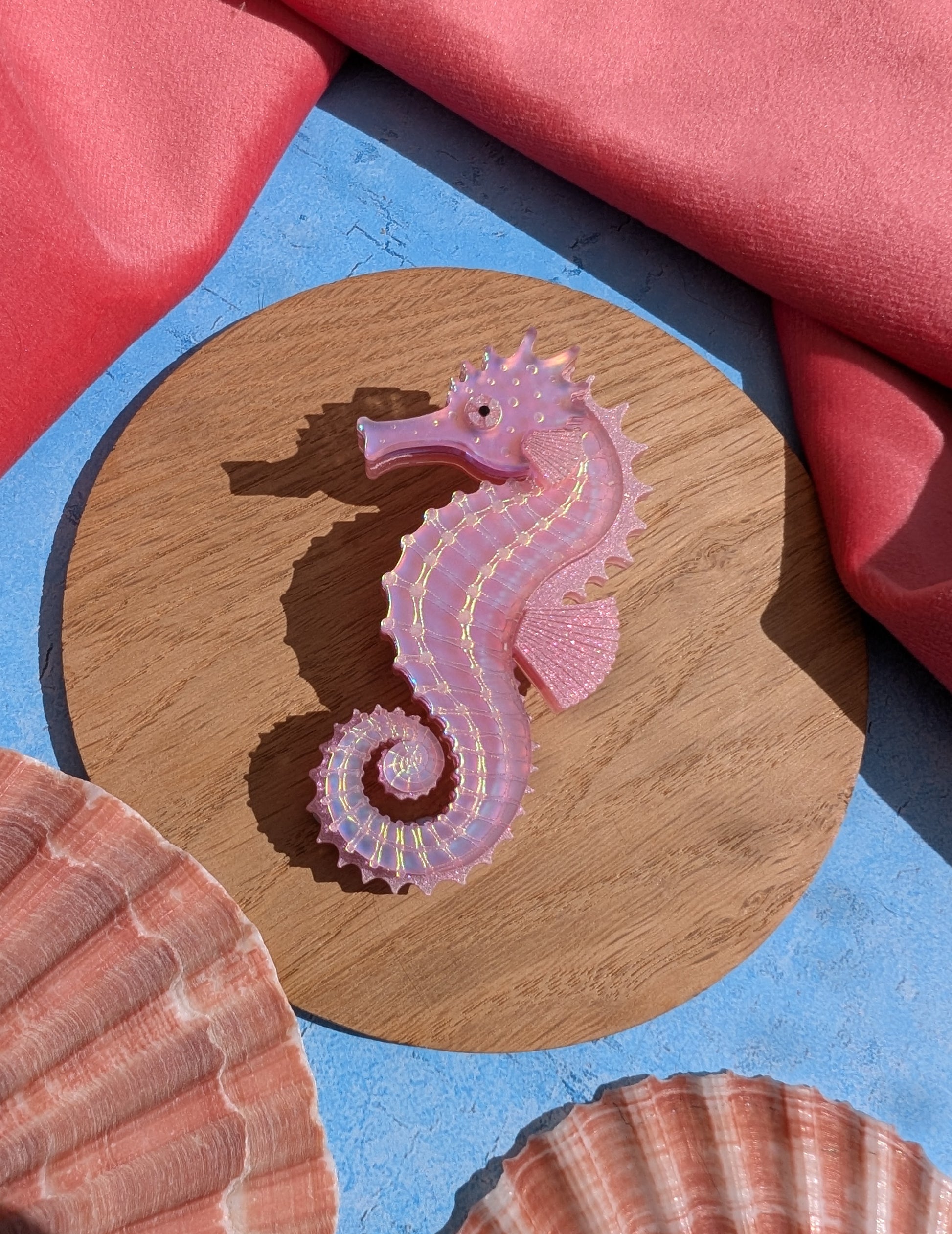 a handmade acrylic pink iridescent seahorse brooch