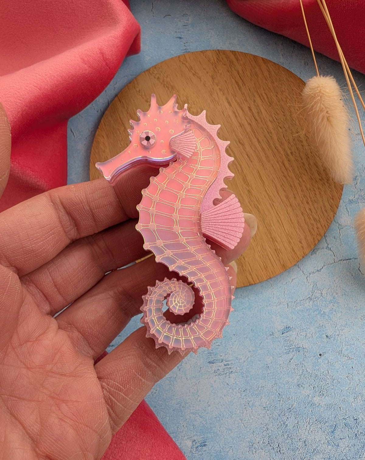 a handmade acrylic pink iridescent seahorse brooch